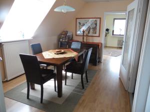 a dining room with a wooden table and chairs at Ferienwohnung Müller Bad Segeberg in Bad Segeberg