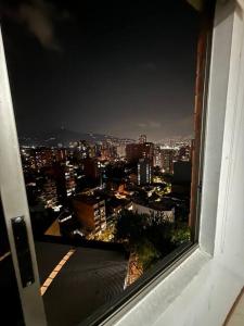 widok na miasto w nocy z okna w obiekcie Hermoso apartamento en Sabaneta w mieście Sabaneta
