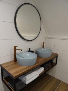 La salle de bains est pourvue de 2 lavabos et d'un miroir. dans l'établissement B&B Geniet Nátuurlijk, à Wapserveen