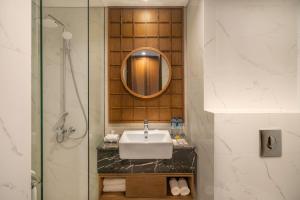 un baño con lavabo y espejo en Lavaya Resort Nusa Dua Bali, en Nusa Dua