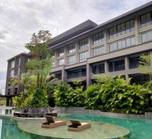 un edificio con 2 sillas frente a una piscina en Lavaya Resort Nusa Dua Bali, en Nusa Dua