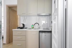 a white kitchen with a sink and a dishwasher at AR APARTMENTS in Nikiti +17 photos