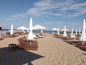 ソポトにあるSopot Holiday - Apartament przy plażyの砂浜のビーチ(椅子、パラソル付)