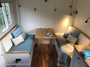 a tiny house with a bench and a table at Green Valley, Cotswold stay with hamper in Cheltenham