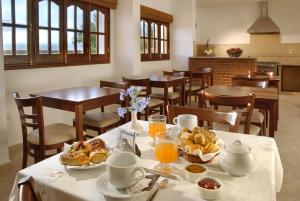 a dining room with a table with breakfast food on it at Posada Cerro Hotel in Santa Rosa de Calamuchita
