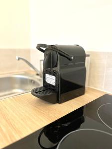 a black toaster sitting on a counter next to a sink at M024 Studio avec balcon gare in Annemasse