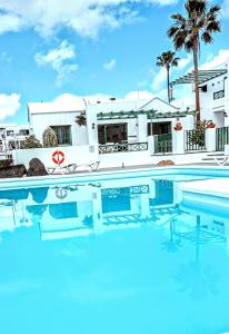 una piscina con una casa en el fondo en Apartamentos las Acacias, en Puerto del Carmen