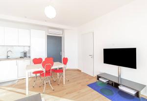 a living room with a table and chairs and a television at Stunning Sea View 1 bedroom Near Monaco in Beausoleil
