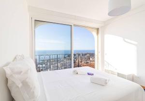 um quarto com uma cama branca e uma grande janela em Amazing Sea View T2- Near Monaco em Beausoleil
