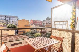 a balcony with a wooden table and two chairs at Pretty T2 In Peace With Parking Menton in Menton