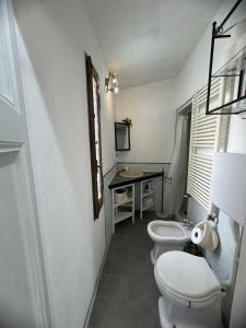 a bathroom with two toilets and a desk with a window at Maison Leone Apartment in Ravenna +13 photos