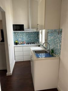 a small kitchen with a sink and a stove at Maison Leone Apartment in Ravenna