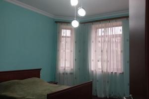 1 dormitorio con 1 cama y 2 ventanas con cortinas en Сдается стильный особняк в Ереване! en Ereván