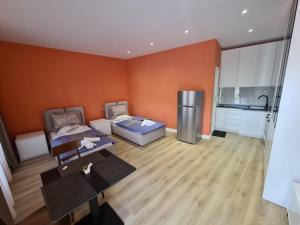 a living room with orange walls and a kitchen at Tirana Center Apartaments in Tirana