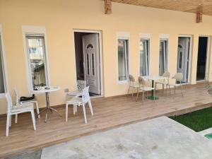 a patio with white chairs and tables and windows at Tirana Center Apartaments in Tirana