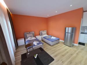 a small room with two beds and a refrigerator at Tirana Center Apartaments in Tirana