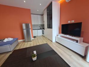 a large living room with an orange wall at Tirana Center Apartaments in Tirana