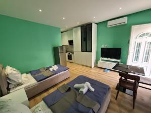 a living room with two beds and a television at Tirana Center Apartaments in Tirana