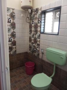 uma casa de banho com um WC verde e uma janela em Lovedale homestay em Ooty