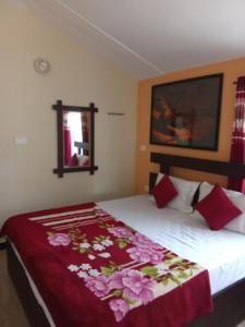 a bedroom with a bed with a red blanket at Lovedale homestay in Ooty