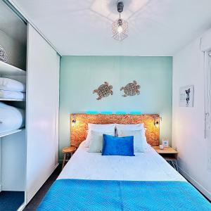 a bedroom with a large bed with blue accents at Sweet apartment in front of Disneyland's castel in Montévrain