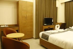 a hotel room with two beds and a television at COSMO GRANDE in Chennai