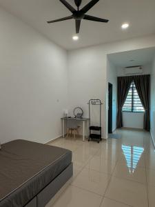 a bedroom with a bed and a table and a ceiling fan at 9 Homestay - Feel like home . in Muar