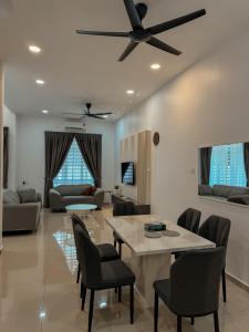 a living room with a ceiling fan and a table and chairs at 9 Homestay - Feel like home . in Muar