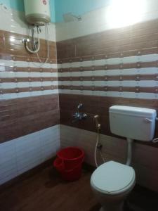 a bathroom with a toilet and a bucket at Lovedale homestay in Ooty