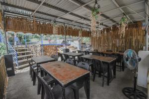 um restaurante com mesas e cadeiras e uma ventoinha em EL BOSQUE RESORT CORON em Coron