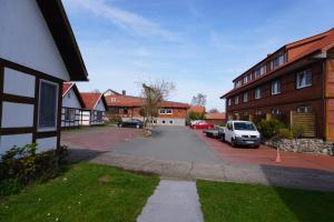 a street with cars parked in front of a building at Alcor Hotel Feriendorf an der Ostsee in Wohlenberg