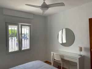a bedroom with a bed and a dressing table and a ceiling fan at Modern and airy holiday home in Torrevieja
