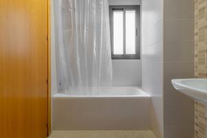 La salle de bains blanche est pourvue d'une baignoire et d'un lavabo. dans l'établissement Apartment downtown Merida Close to Roman Theater, à Mérida