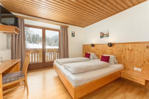 1 dormitorio con 1 cama y pared de madera en Winklhütte, en Forstau