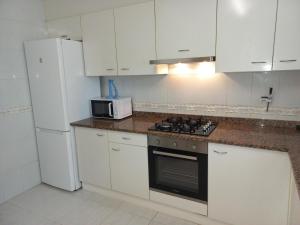 cocina con armarios blancos, fogones y microondas en Casa Sant Pere Pescador, 3 dormitorios, 6 personas - ES-89-89, en Sant Pere Pescador