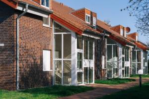 een bakstenen gebouw met grote glazen deuren erop bij Tallskog - Dein Apartment am Naturstrand Hohen Wieschendorf in Hohenkirchen