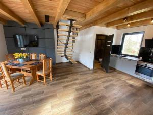 a kitchen and dining room with a table and a spiral staircase at Rodzinna Przystań in Lubawka +18 photos
