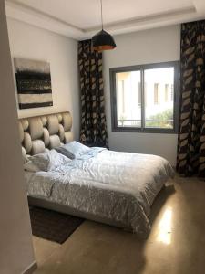 a bedroom with a bed and a window at 5 Star Apartment Near Airport in Nouaseur