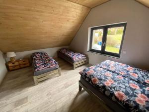 Zimmer im Dachgeschoss mit 2 Betten und einem Fenster in der Unterkunft Rodzinna Przystañ in Lubawka