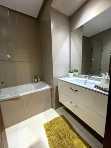 a bathroom with a sink and a tub and a mirror at 5 Star Apartment Near Airport in Nouaseur