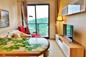 een woonkamer met een groot raam en een televisie bij unixx city ​​center high floor amazing sea view24f in Pattaya South