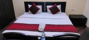 a bedroom with a large bed with red and black pillows at Hotel Marigold in New Delhi