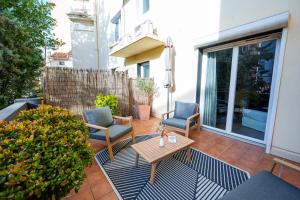 a patio with two chairs and a table at Nyx Hôtel Indépendant Perpignan Centre Gare in Perpignan