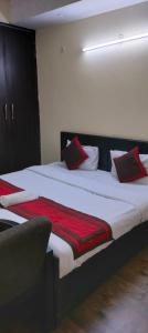 Hotel Marigold في نيودلهي: غرفة نوم بسريرين ومخدات حمراء