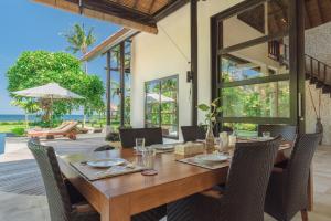- une salle à manger avec une table et des chaises en bois dans l'établissement Villa Banjar Beach, à Banjar