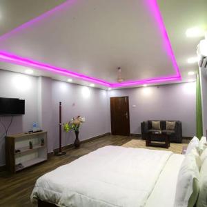 a bedroom with a large bed with a pink lighting at Cozy Nest Homestay in Guwahati