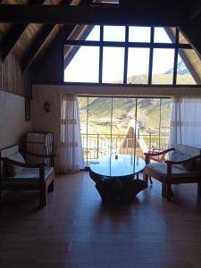 a living room with a large window and a table at Mountain Breeze in Qırızdǝhnǝ