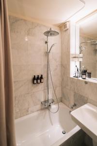 een badkamer met een douche, een bad en een wastafel bij Tallskog - Dein Apartment am Naturstrand Hohen Wieschendorf in Hohenkirchen