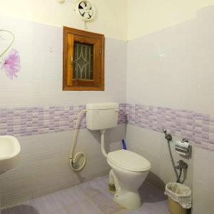 a bathroom with a toilet and a sink at Cozy Nest Homestay in Guwahati