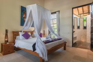 1 dormitorio con 1 cama con mosquitera en Villa Banjar Beach, en Banjar